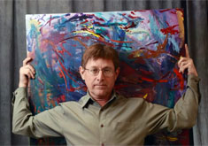 Photo: Artist holding painting behind
