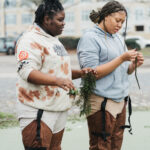 Image: Environmentors standing in water looking at vegetation